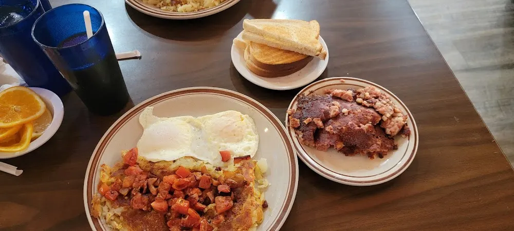 Corned Beef Hash 2 over Easy Eggs Crispy Hash Browns with Dice Tomatoes on Top White Toast